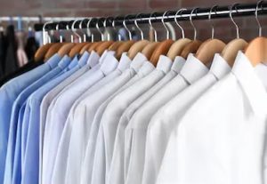 Different colour shirts hanging on hangers at Ilford Dry Cleaners